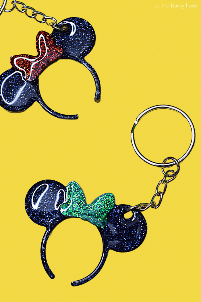 Minnie Mouse ears keychains on yellow background. 