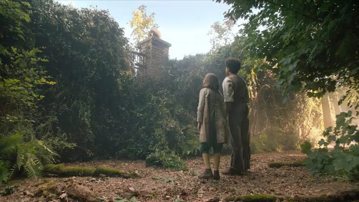 Mary and Dickon stand outside the secret garden gate. 