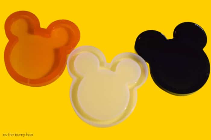 Disney Halloween Shakers on yellow background. Resin mold and cured resin in orange and black. 
