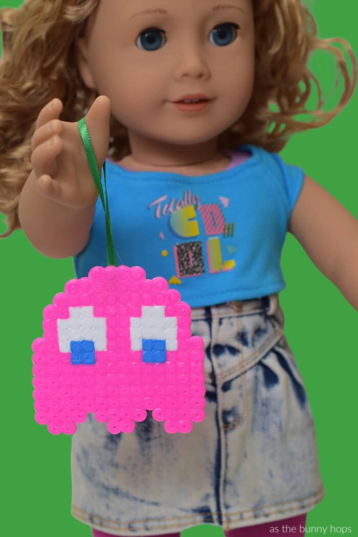 Make some totally cool 80s-inspired perler bead Pac-Man Christmas Ornaments! 
American Girl Courtney holding pink ghost ornaments. 