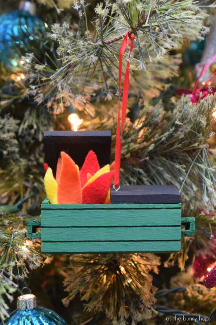 Celebrate this dumpster fire of a year with a DIY Dumpster Fire Ornament. 
Ornament hanging on tree. 