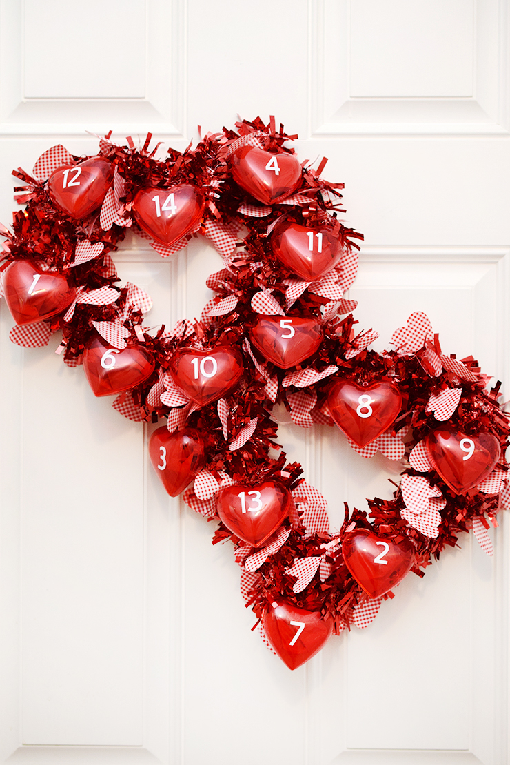 Valentine's Day countdown calendar wreath with two hearts and little heart ornaments full of treats.